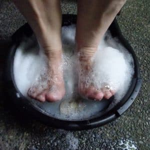השרייה של כפות הרגליים במים וסבון יכולה למנוע ציפורן חודרנית