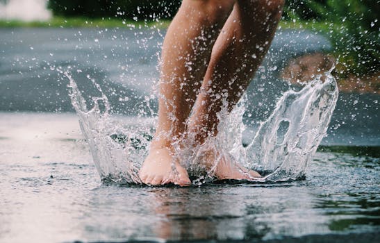 Bare feet splashing in a puddle, capturing the joy of a rainy day outdoors.